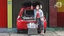 Cynthia (28) mahasiswi perguruan tinggi swasta menunggu pembeli di Jalan Santosa, Depok, Jawa Barat, Kamis (21/5/2020). Cynthia menggunakan mobil pribadinya sebagai lapak berjualan berbagai macam sayuran dengan harga serba Rp 5.000. (Liputan6.com/Herman Zakharia)