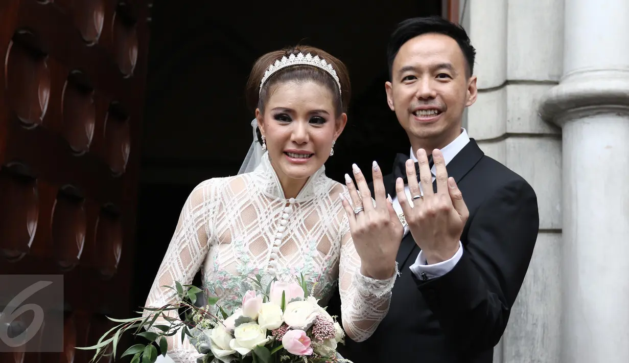 Aktris Olga Lydia dan Aris Utama memamerkan cincin seusai menjalankan sakramen pernikahan di Gereja Katedral, Jakarta, Jumat (21/4). Aktris Olga Lydia dan Aris Utama menjalankan sakramen pernikahan. (Liputan6.com/Herman Zakharia)