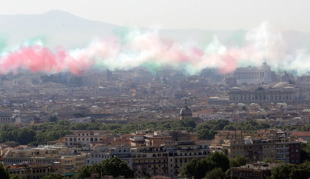 Asap berwarna bendera Italia yang dikeluarkan oleh tim aerobatik Frecce Tricolori selama parade militer ulang tahun Hari Republik Italia ke-72 di Roma, Sabtu (2/6). (AP Photo/Claudio Peri)