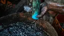 Pekerja mengumpulkan minyak mentah saat melakukan pengeboran di sumur minyak ilegal di Minhla, Myanmar, 10 Maret 2019. Para pekerja dapat memperoleh hingga 600 barel minyak per hari. (Ye Aung THU/AFP)