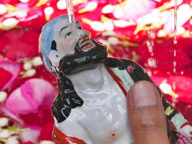Patung dewa Tionghoa dibersihkan untuk persiapan perayaan Tahun Baru Imlek di Vihara Dhanagun, Bogor, Jawa Barat, Indonesia, 16 Januari 2023. Warga keturunan Tionghoa di Indonesia bersiap untuk merayakan Tahun Baru Imlek pada 22 Januari 2023. (AP Photo/Tatan Syuflana)