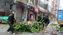 Warga memindahkan pohon tumbang akibat Topan Mujigae di Maoming, Provinsi Guangdong, China, Minggu (4/10/2015). Topan dengan kecepatan angin hingga 180 km per jam menghantam pantai selatan China dan menewaskan sedikitnya empat orang. (REUTERS/Stringer)