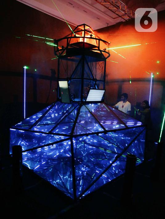 Pengunjung melihat pameran seni berbasis teknologi berwujud sorotan cahaya futuristik 'Wave of Tomorrow' di Jakarta, Sabtu (21/12/2019). Pameran seni Wave of Tomorrow menghadirkan tiga kelompok instalasi yaitu legacy, now, dan tomorrow.  (Liputan6.com/Faizal Fanani)