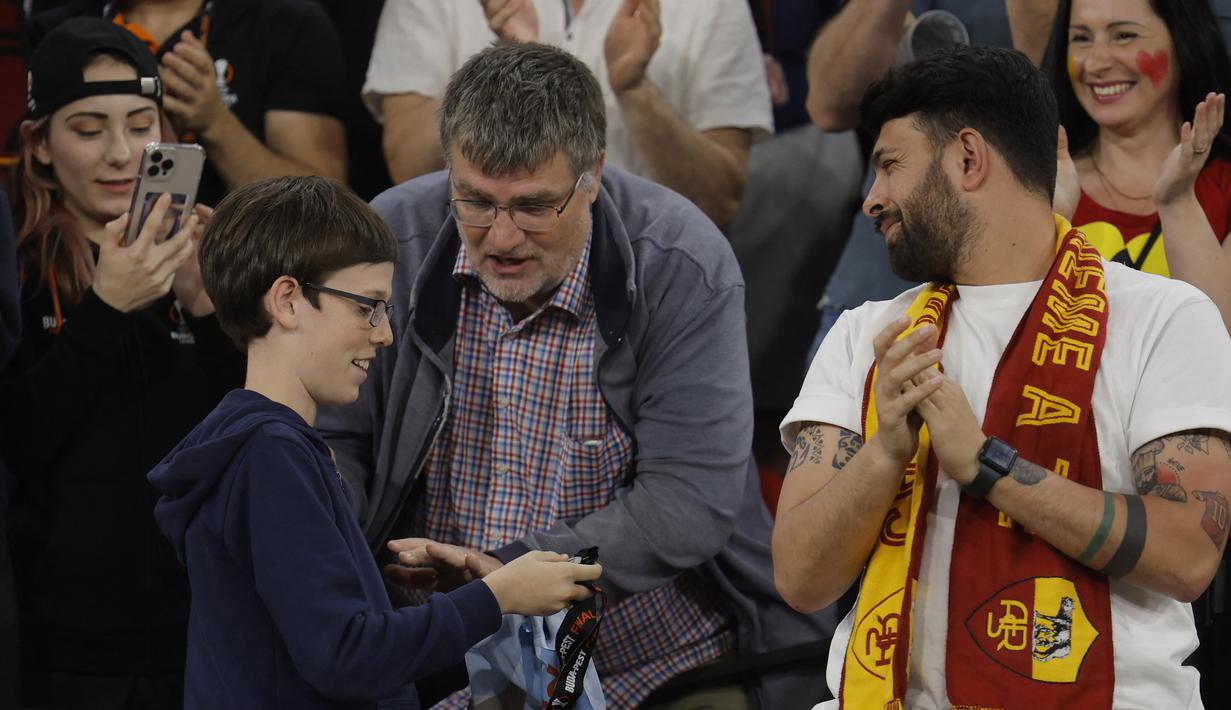 Seorang suporter cilik AS Roma memegang medali yang diberikan Jose Mourinho setelah pertandingan final Liga Europa 2022/2023 yang berlangsung di Stadion Puskas Arena, Hungaria, Jumat (01/06/2023) dini hari WIB. (AFP/Odd Andersen)