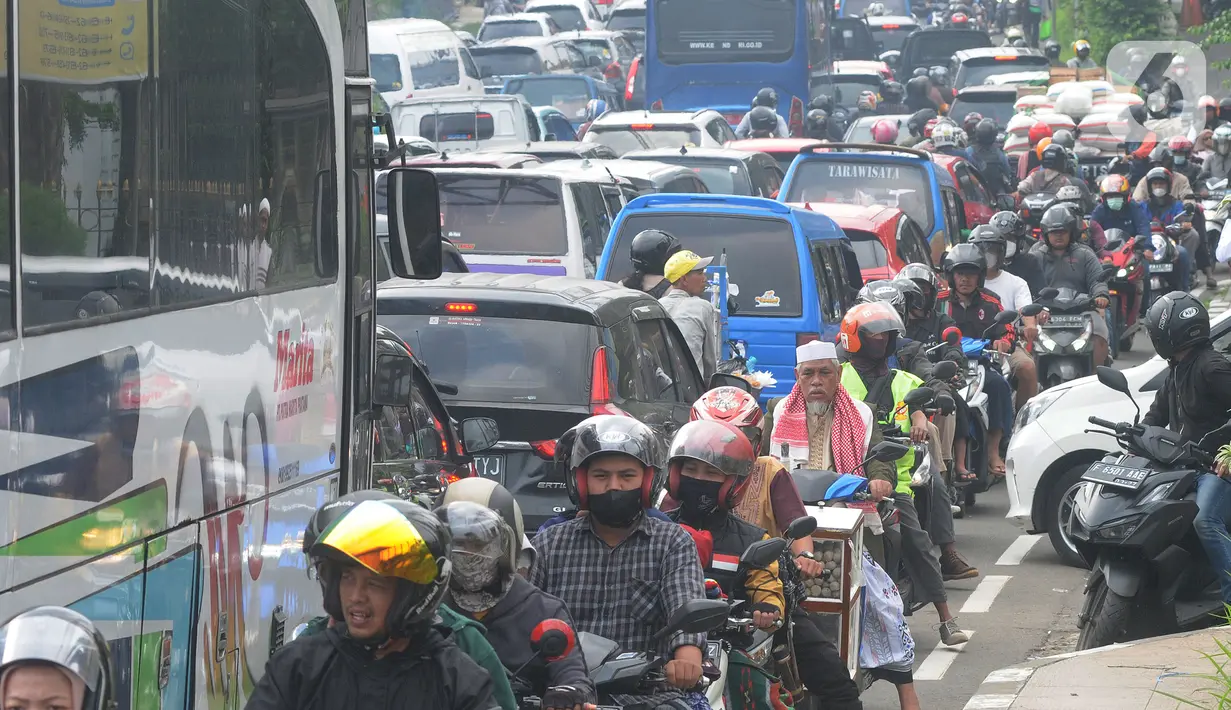 Pengendara berjalan tersendat akibat padatnya volume kendaraan menuju jalur Puncak, Gadog, Bogor, Jawa Barat, Minggu (15/5/2022). Kemacetan panjang kendaraan terjadi di kawasan wisata Puncak memasuki libur panjang Hari Raya Waisak. (merdeka.com/Arie Basuki)