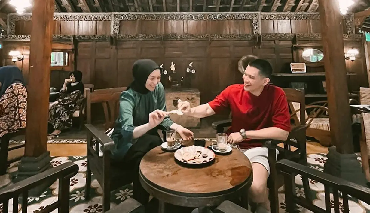 Terbaru, keduanya terlihat tengah liburan di Jogja. Mereka tampak menikmati kuliner lokal. Salah satunya, nongkrong di warung kopi yang disebut juga wedangan. Pasangan artis ini tampak sedang rebutan gorengan. Namun, momen tersebut disebut terlalu romantis oleh warganet. Dalam caption, Rezky menuliskan, "Wedangan karo bojo ku sing paling ayu dewe". (Liputan6.com/IG/@thereal_rezkyadhitya)