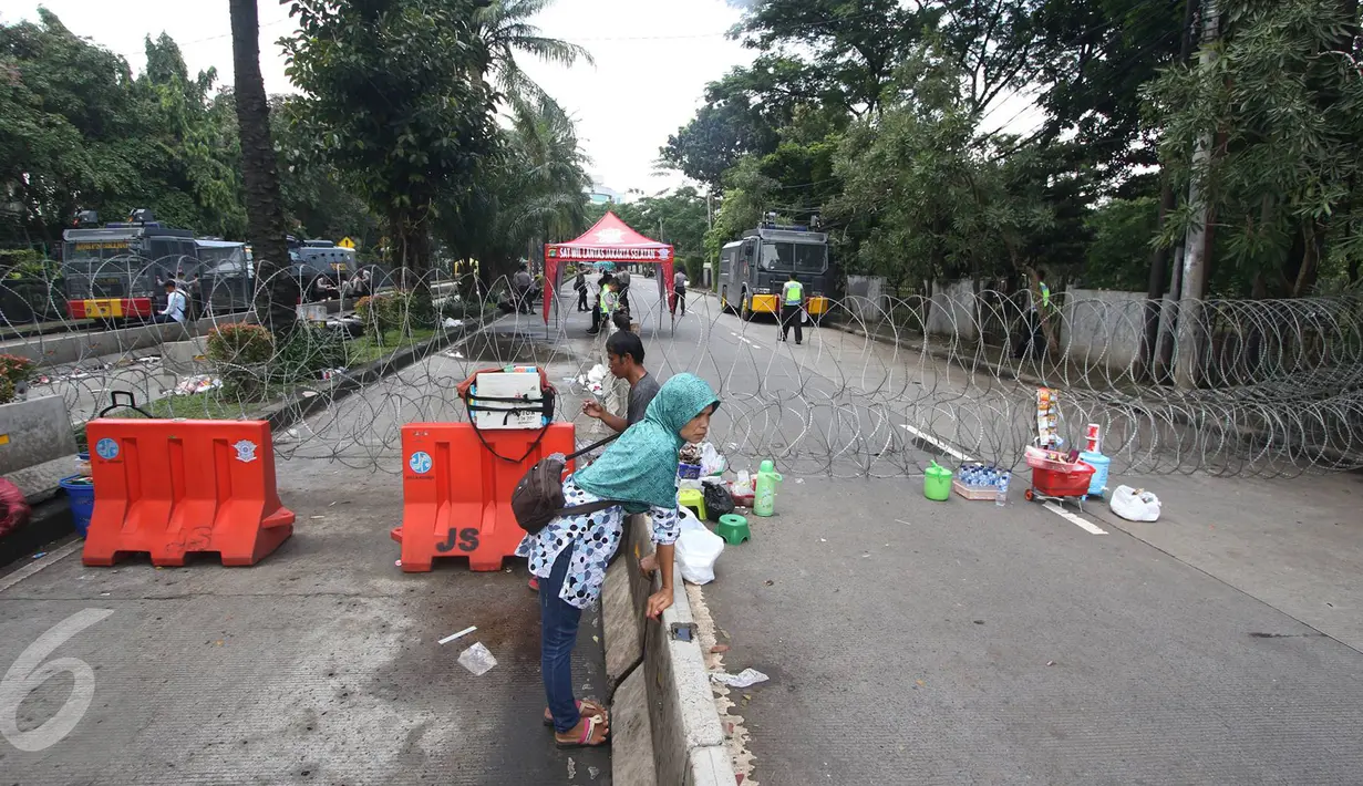  Pedagang dan warga berada di sekitar ruang sidang kasus penistaan agama dengan terdakwa Gubernur DKI Basuki T Purnama, Jakarta, Senin (13/2). Memasuki masa tenang Pilkada, kondisi di luar sidang terpantau lebih sepi. (Liputan6.com/Immanuel Antonius)