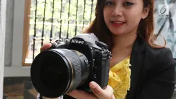 Seorang model berpose sambil menunjukkan kameran Nikon D850 saat peluncuran di Jakarta, Senin (29/1). Keunggulan lain kamera ini adalah sistem 153-point AF, selain itu bisa merekam video full frame dengan kualitas 4K UHD. (Liputan6.com/Angga Yuniar)