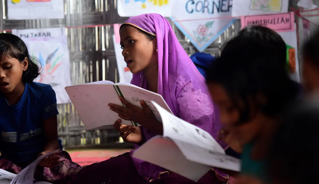 Anak-anak pengungsi Rohingya mengikuti kegiatan belajar di sebuah sekolah darurat di kamp pengungsian di Teknaf, Bangladesh, 8 Oktober 2017. Dengan fasilitas seadanya, relawan berjuang memberikan pendidikan kepada bocah-bocah itu. (MUNIR UZ ZAMAN / AFP)