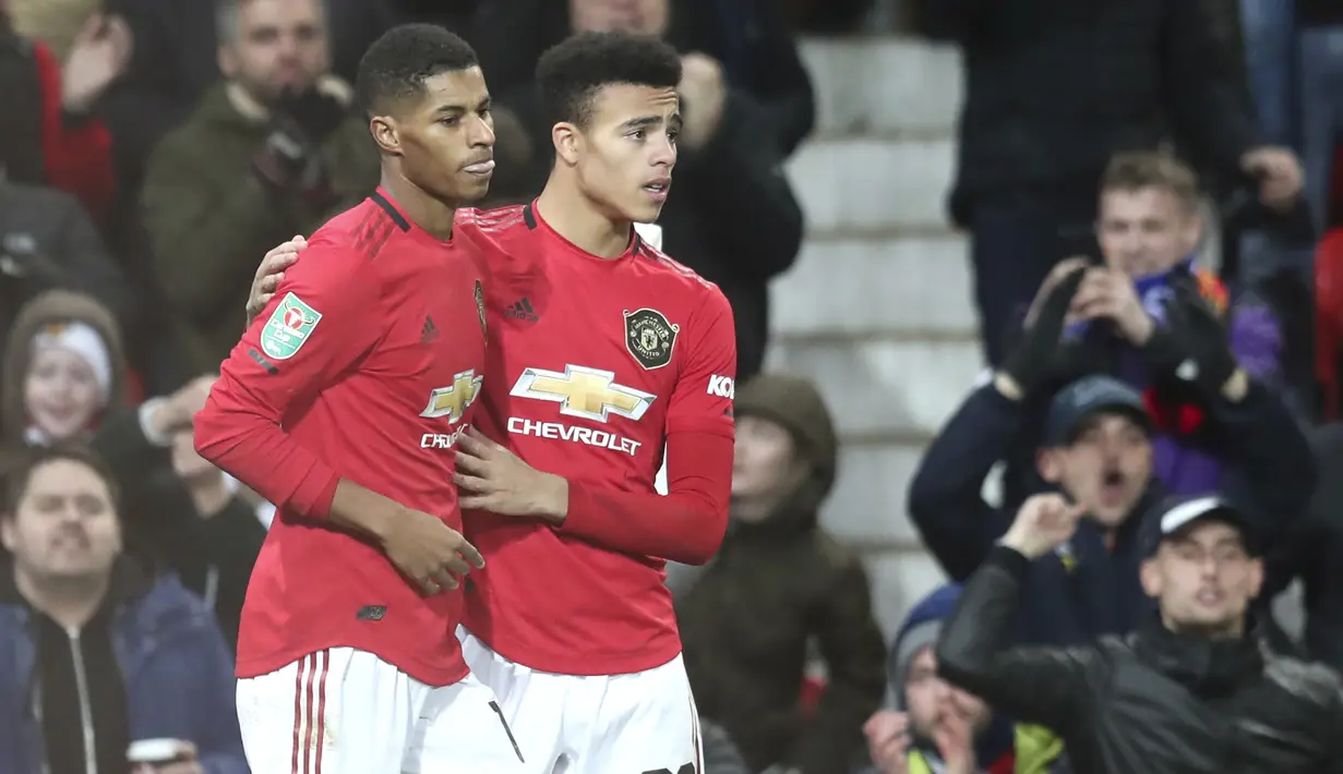 Penyerang Manchester United, Marcus Rashford (kiri) berselebrasi dengan Mason Greenwood usai mencetak gol ke gawang Colchester United pada pertandingan perempat final Piala Liga Inggris di Old Trafford (18/12/2019). MU menang telak 3-0 atas Colchester United. (AP Photo/Jon Super)