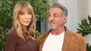 <p>Sylvester Stallone (kanan) bersama istrinya Jennifer Flavin menghadiri Ralph Lauren SS23 Runway Show di The Huntington Library, Art Collections and Botanical Gardens, San Marino, California. Amerika Serikat, 13 Oktober 2022. Sylvester Stallone tampak modis dalam balutan blazer suede cokelat, tee putih polos, celana panjang off-white yang pas, dan sepatu kulit cokelat. (Amy Sussman/Getty Images/AFP)</p>