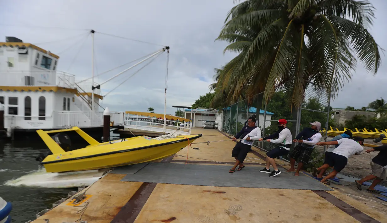 Sejumlah orang memindahkan sebuah perahu saat Badai Delta mendekati Puerto Morelos, Negara Bagian Quintana Roo, Meksiko, 6 Oktober 2020. Status Badai Delta naik menjadi topan tropis kategori 4 pada Selasa (6/10) pagi waktu setempat ketika bergerak menuju Mexican Caribbean. (Xinhua/Mauricio Collado)