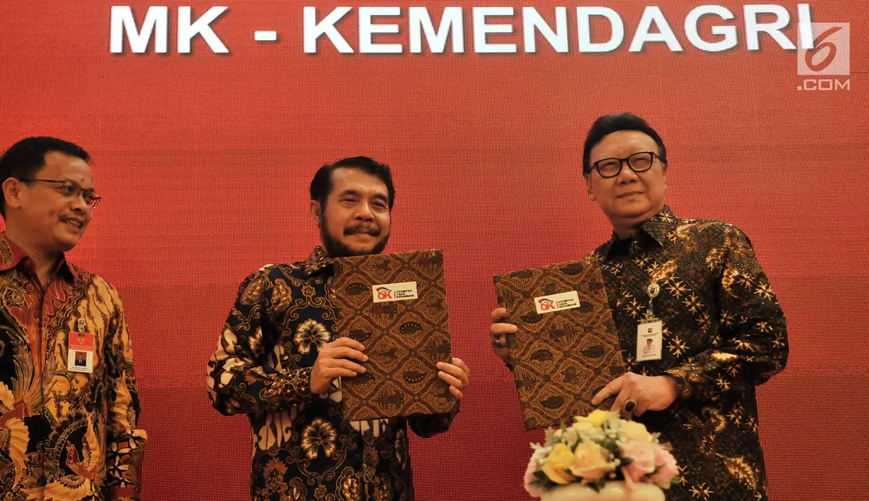 Mendagri Tjahjo Kumolo (kanan) dan Ketua MK Anwar Usman (tengah) menunjukkan dokumen Nota Kesepahaman di Jakarta, Selasa (19/2). Kerja sama ini juga untuk penegakan hukum dan mencegah terjadinya kriminalitas. (Merdeka.com/Iqbal Nugroho)