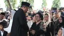 Presiden ke-6 RI Susilo Bambang Yudhoyono bersalaman dengan Presiden ke-5 RI Megawati Soekarnoputri usai prosesi pemakaman Ani Yudhoyono di TMP Kalibata, Jakarta, Minggu (2/6/2019). Megawati tampak melempar senyum kepada SBY disamping Sinta Nuriyah Wahid. (Liputan6.com/HO/Rangga)