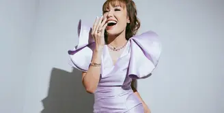 Ayu Dewi tampil luar biasa dalam balutan gaun bernuansa ungu muda. Midi dress yang dikenakan Ayu Dewi di foto ini memiliki detail lengan beraksen yang mempercantik keseluruhan penampilannya. Tatanan rambut berponi dan riasan wajah yang bernuansa hangat, serta aksesori yang dikenakannya semakin membuat penampilan Ayu Dewi terlihat sempurna. Foto: Instagram.