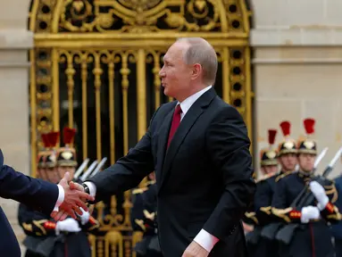 Presiden Prancis Emmanuel Macron menyambut kedatangan Presiden Rusia, Vladimir Putin di Istana Versailles, dekat Paris, Senin (29/5). Macron bertemu tatap muka untuk pertama kalinya dengan Vladimir Putin. (AP Photo/Alexander Zemlianichenko, pool)