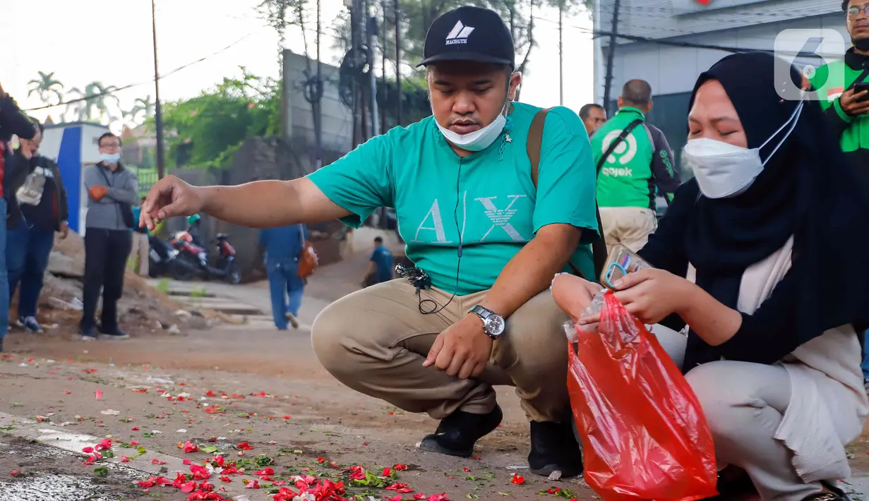 Sejumlah kerabat korban dan warga melakukan tabur bunga di lokasi kecelakaan maut di Jalan Transyogi, Cibubur, Bekasi, Jawa Barat, Rabu (20/7/2022). Aksi tabur bunga tersebut sebagai bentuk rasa duka cita atas meninggalnya 11 orang korban kecelakaan maut di kawasan tersebut. (Liputan6.com/Herman Zakharia)