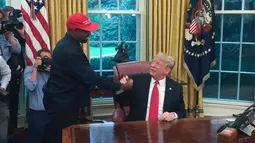 Presiden AS, Donald Trump bertemu dengan rapper Kanye West di Oval Office, Gedung Putih, Kamis (11/10). Kali ini, pertemuan Trump dan Kanye West untuk membahas ketersediaan lapangan kerja bagi mantan narapidana. (SEBASTIAN SMITH / AFP)