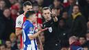 Wasit Clement Turpin (kanan) saat mengambil keputusan pada laga leg kedua 16 besar Liga Champions 2023/2024 antara Arsenal Melawan Porto di Emirates Stadium, London, Inggris, Rabu (13/03/2024) dini hari WIB. (AFP/Adrian Dennis)
