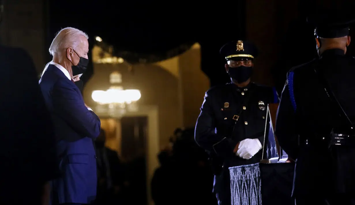 Presiden AS Joe Biden dan Ibu Negara Jill Biden memberi penghormatan kepada polisi yang tewas dalam kerusuhan Capitol Hill Brian Sicknick di tengah Capitol Rotunda, Washington, Selasa (2/2/2021). Abu jenazah Brian Sicknick dihadirkan dalam upacara ini. (Leah Millis/Pool via AP)