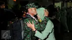 Personel TNI AD yang tergabung dalam kontingen AASAM mencium kening pasangannya saat penyambutan kedatangan di Bandara Soetta, Banten, Senin (23/5/2016). TNI AD menjadi juara umum AASAM 2016 yang digelar di Australia. (Liputan6.com/Helmi Fithriansyah)