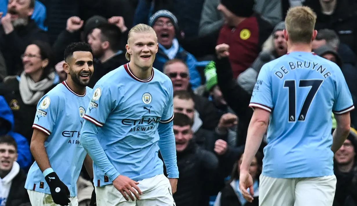 <p>Erling Haaland (tengah) berselebrasi dengan rekan setimnya setelah mencetak gol pertama untuk Manchester City ke gawang Wolves selama pertandingan lanjutan Liga Inggris di Stadion Etihad di Manchester, Inggris (22/1/2023). Di pertandingan ini, Haaland mencetak tiga gol. (AFP/Paul Ellis)</p>
