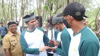 Wakil Gubernur Jawa Timur Emil Elestianto Dardak (kaos Putih Hijau) didampingi Wakil Bupati Banyuwangi Sugirah  menyerahkan bibit mangrove ke  warga Pantai Cemara di Kawasan Ekosistem Ekslusif untuk ditanam (Istimewa)