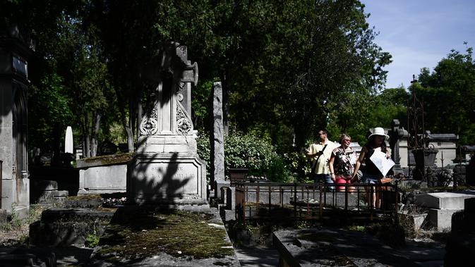 Turis mengunjungi pemakaman Pere Lachaise di Paris (22/7/2019). Pemakaman ini paling banyak didatangi wisatawan di dunia. Artis dan banyak tokoh terkenal dimakamkan di sini. (AFP Photo/Philippe Lopez)
