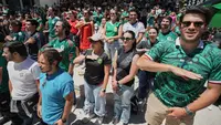 Para penggemar Meksiko menyanyikan lagu kebangsaan Meksiko saat mereka menyaksikan siaran langsung pertandingan pembukaan turnamen sepak bola Piala Dunia antara Meksiko dan Afrika Selatan di San Francisco, Jumat (12-6-2026) dini hari WIB. (AP Photo/Eugene Hoshiko)