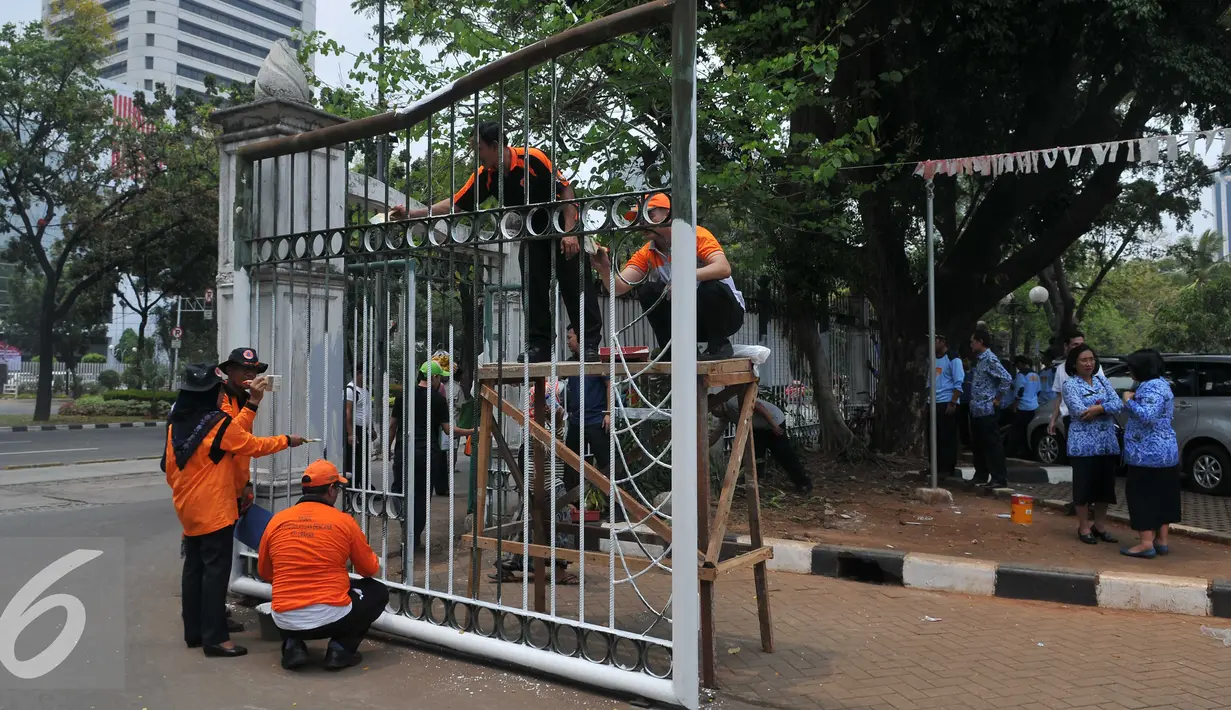 Sejumlah pegawai pemerintah Provinsi DKI mengecat pagar Monumen Nasional (Monas) di Jakarta, Selasa(10/11). Pengecetan pagar Monas dilaksanakan dalam rangka memperingati Hari Pahlawan yang jatuh pada tanggal 10 November. (Liputan6.com/Gempur M Surya)