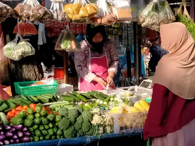 Seorang perempuan membeli sayur mayur di salah satu lapak Pasar Mega, Gunung Putri, Kabupaten Bogor, Jawa Barat, Senin (5/9/2022). Kebijakan kenaikan harga bahan bakar minyak (BBM) berdampak pada kondisi harga kebutuhan bahan pokok di pasar. (Liputan6.com/Magang/Aida Nuralifa)