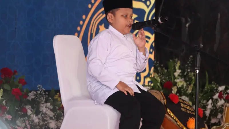 Raehan Khoiri (Rafa), anak dengan disabilitas netra yang hafal 15 juz alquran melantunkan ayat suci dalam HUT ke-78 Bhayangkara (Liputan6.com/Fira Syahrin).
