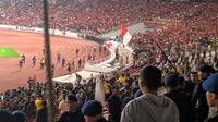 Suporter Malaysia menyelamatkan diri ke lapangan setelah dilempar bom asap oleh suporter Timnas Indonesia di Stadion Utama Gelora Bung Karno (SUGBK), Jakarta, Kamis (5/9/2019) malam. (Bola.com/Muhammad Adiyaksa)