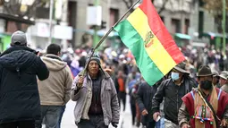 Seorang pria memegang bendera Bolivia selama demonstrasi menentang Presiden Rodrigo Paz di La Paz pada 25 Mei 2026. (Marvin RECINOS/AFP)