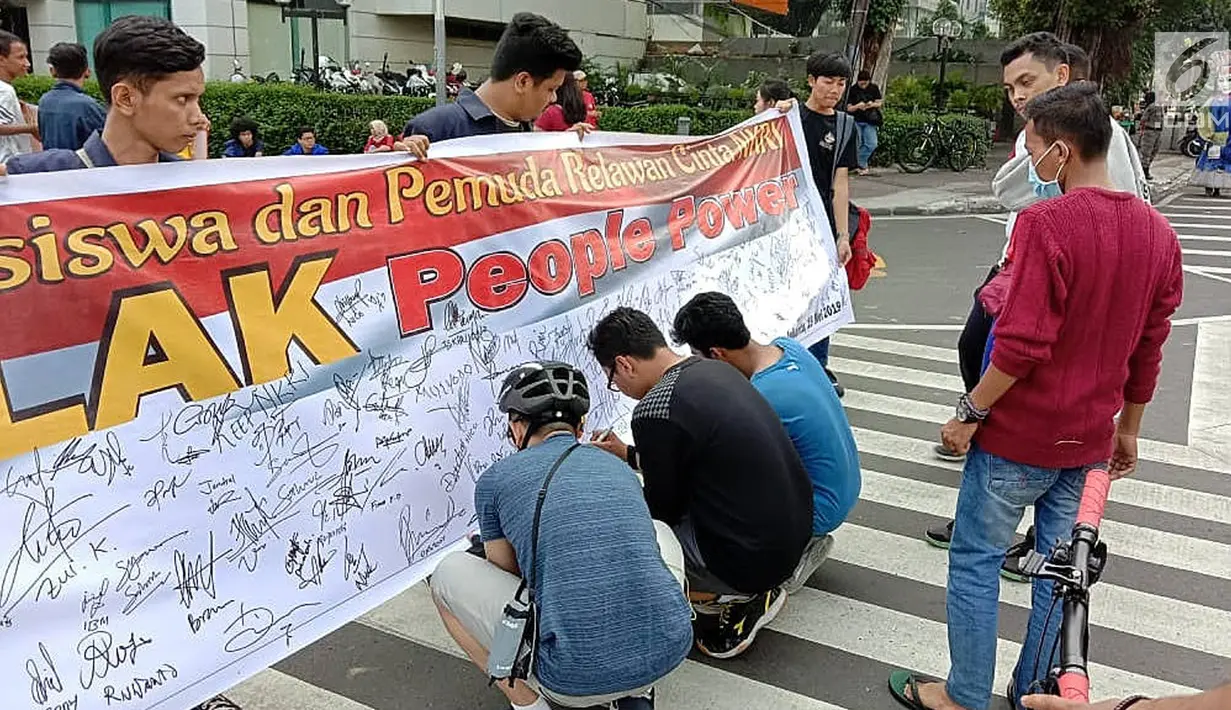 Masyarakat menandatangi spanduk petisi menolak gerakan people power saat car free day (CFD) di kawasan Thamrin, Jakarta, Minggu (19/5/2019). Aliansi Mahasiswa dan Pemuda Cinta NKRI mengajak masyarakat menandatangani petisi mendukung KPU dan Bawaslu pasca Pilpres 2019. (Liputan6.com/Faizal Fanani)