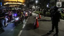 Suasana mobilitas warga saat perayaan malam Tahun Baru di Jakarta, Jumat (31/12/2021). Polda Metro Jaya melakukan pengendalian mobilitas Crowd Free Night (malam bebas keramaian) dengan membubarkan warga yang nekat keluar rumah dan tidak mematuhi aturan. (Liputan6.com/Johan Tallo)