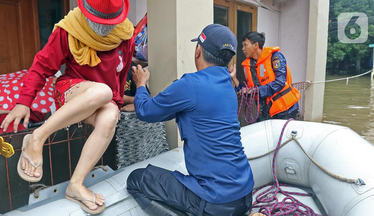 Petugas mengevakuasi warga yang terjebak banjir di RW 07, Kelurahan Pekayon, Jakarta Timur, Sabtu (20/2/2021). Banjir di kawasan tersebut terjadi akibat curah hujan yang tinggi. (Liputan6.com/Herman Zakharia)