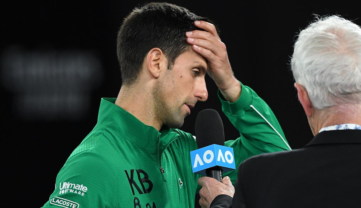 Petenis Serbia, Novak Djokovic, menangis saat diwawancara tentang Kobe Bryant seusai laga Australia Open 2020 di Melbourne, Selasa (28/1). Beri penghormatan dirinya memakai jaket inisial Kobe Bryant. (AFP/Greg Wood)