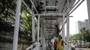 Pekerja menyelesaikan pembangunan bagian atap jembatan penyebrangan yang terhubung dengan halte busway BNN di Kawasan Cawang Jakarta, Jumat (2/3). (Liputan6.com/Faizal Fanani)