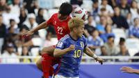 Gelandang Vietnam, Khuat Van Khang dan gelandang Jepang, Ritsu Doan melompat untuk menyundul bola dalam laga Grup D Piala Asia 2023 Qatar di Stadion Al-Thumama, Doha, Qatar, Minggu (14/1/2023). (AFP/Karim Jaafar)