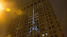 Proyeksi Menara Eiffel ditampilkan di sisi bangunan Flatiron New York City, Rabu (18/11). Gambar yang menampilkan tulisan 'She is tossed by waves but does not sink' itu bentuk solidaritas terkait serangan teror Paris. (Andrew Burton/Getty Images/AFP)