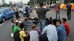 Dalam aksinya, sempat terjadi kemacetan karena massa membuat lingkaran dan duduk di tengah jalan, Jakarta, (23/9/14). (Liputan6.com/Miftahul Hayat)