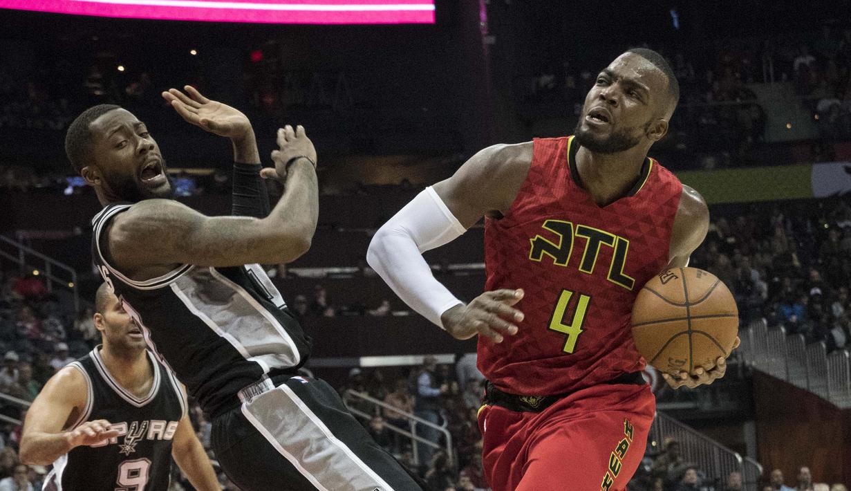 Pemain Atlanta Hawks, Paul Millsap (kanan) menggiring bola melewati hadangan pemain Spurs, Jonathon Simmons pada lanjutan NBA basketball game di Philips Arena, (01/01/2017). Atlanta menang 114-112. (AP/John Amis)
