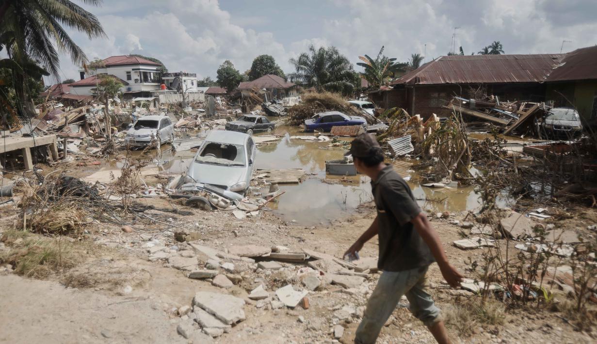 Puing-puing mobil berserakan di area yang hancur akibat banjir bandang di Aceh Tamiang, Jumat 5 Desember 2025. Sepekan lebih pasca terjangan banjir bandang, situasi dan kondisi Kabupaten Aceh Tamiang masih sangat memprihatinkan. (AP Photo/Binsar Bakkara)