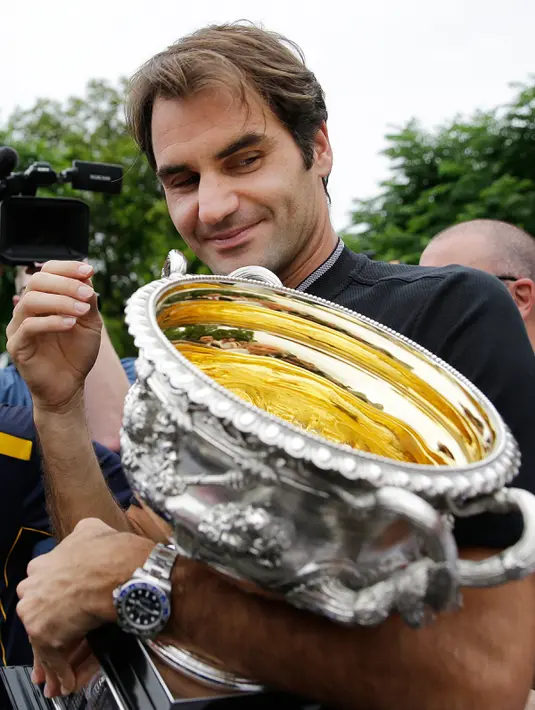 Ekspresi Roger Federer saat memegang trofi Australian Open 2017 di Carlton Gardens di Melbourne, Australia (30/1). Kemenangan Federer di Australian Open 2017 membuat dirinya meraih gelar ke-18 Grand Slam. (AP Photo / Aaron Favila)