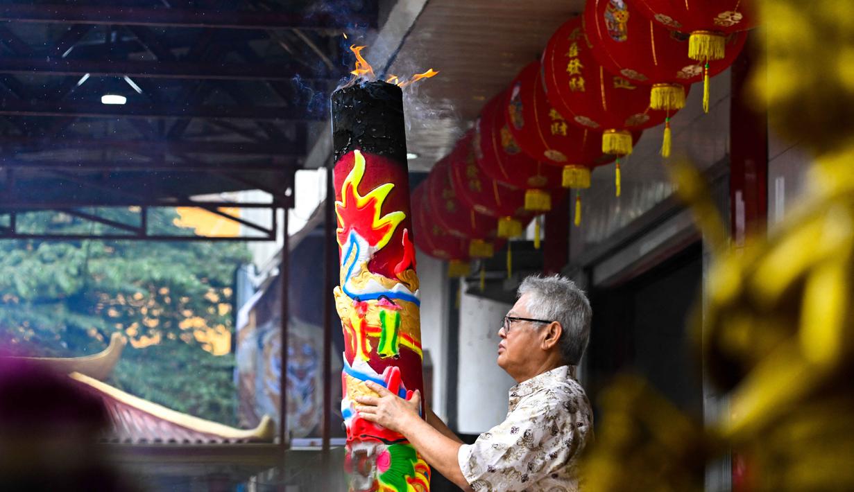 Berbeda dengan tahun-tahun sebelumnya yang meriah, perayaan Imlek di Banda Aceh kali ini difokuskan pada doa bersama untuk keselamatan dan pemulihan para korban bencana. Tampak dalam foto, seorang pria membakar dupa saat berdoa di sebuah kuil pada hari pertama Tahun Baru Imlek 2577 Kongzili di Banda Aceh, Provinsi Aceh, pada Selasa 17 Februari 2026. (CHAIDEER MAHYUDDIN/AFP)