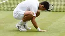 Novak Djokovic mengambil rumput lapangan dan memakannya menjadi ritual baginya bila meraih gelar Wimbledon. (EPA/FACUNDO ARRIZABALAGA)