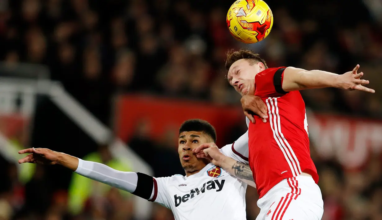 Bek MU, Phil Jones (kanan) berebut bola udara dengan penyerang West Ham United, Ashley Fletcher di perempat final Piala Liga (EFL Cup) di Stadion Old Trafford, Inggris, (1/12). MU menang telak atas West Ham dengan skor 4-1. (Reuters/Phil Noble)