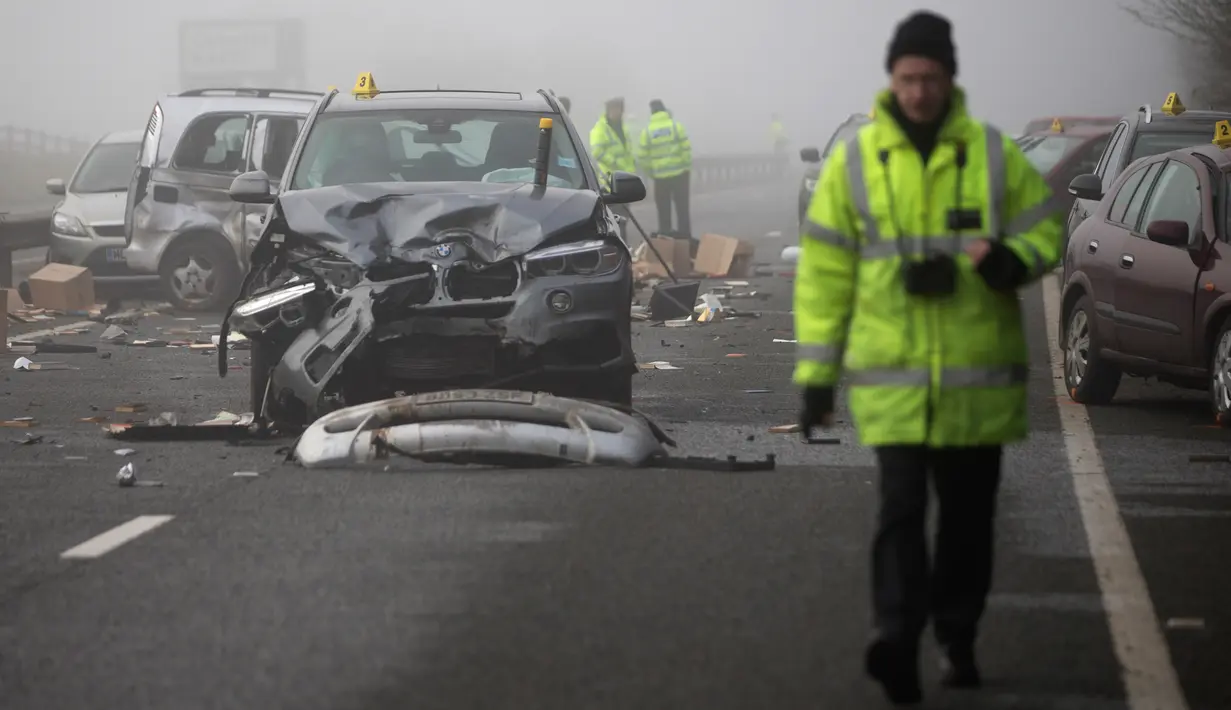 Petugas layanan darurat dikerahkan ke lokasi kecelakaan beruntun yang melibatkan sekitar 20 mobil di Oxfordshire, Inggris, Rabu (28/12). Satu orang perempuan meninggal dunia dan lebih dari 12 orang lainnya luka-luka. (AFP PHOTO/Daniel LEAL-OLIVAS) 