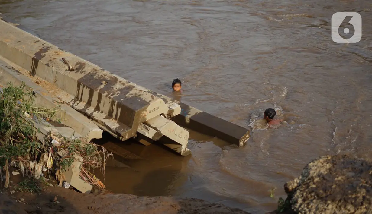 Anak-anak berenang di bantaran Sungai Ciliwung, Jakarta, Senin (5/10/2020). Derasnya aliran Sungai Ciliwung akibat hujan deras yang mengguyur Jakarta tidak menyurutkan kemauan anak-anak tersebut untuk tetap berenang, meski dapat membahayakan keselamatan mereka. (Liputan6.com/Immanuel Antonius)